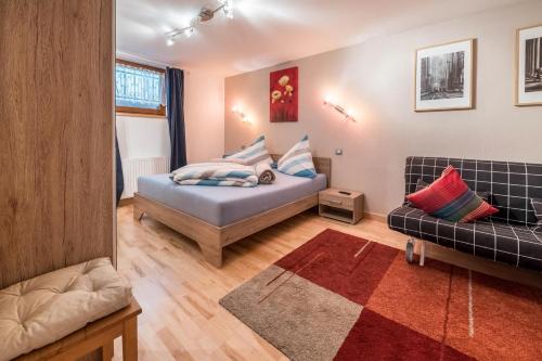 ein Schlafzimmer mit einem Bett und einer Couch in der Unterkunft Wieseneck ii - Apartment in Fügen in Fügen