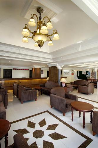 a lobby with couches and tables and a stage at Berjaya Praslin Resort in Anse Volbert Village