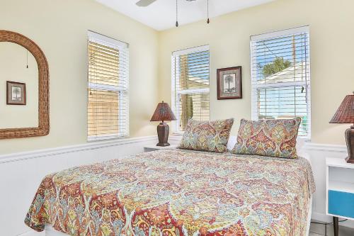 a bedroom with a bed and two windows at Seaside Sweetheart in Clearwater Beach