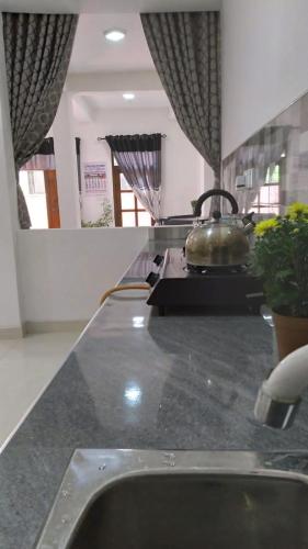 a kitchen counter with a tea kettle on a stove at Flower Top Ella in Ella