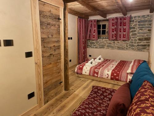 a bedroom with two beds and a sliding barn door at Rascard Monterosa in Champoluc
