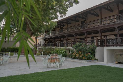 uma mesa e cadeiras em frente a um edifício em Tree of Life Darbargadh Dared em Bhavnagar