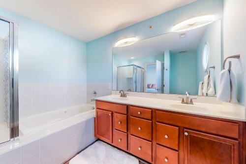 a bathroom with a tub and a sink and a mirror at Bayside at Bethany Lakes #143 in Ocean View
