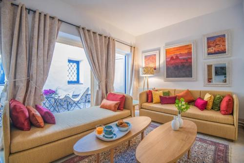 a living room with two couches and a table at La Demeure in Sidi Bou Saïd
