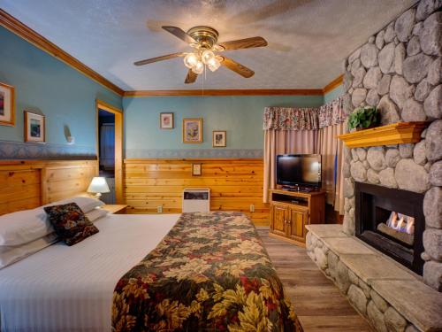 um quarto com uma cama grande e uma lareira em Cathy's Cottages em Big Bear Lake