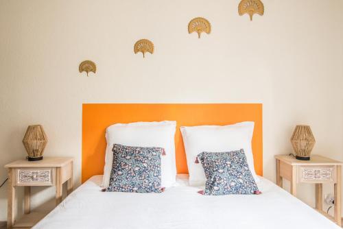 - une chambre avec un lit doté d'une tête de lit orange et d'oreillers dans l'établissement Soraya - 5min de la gare & du centre, à Colmar