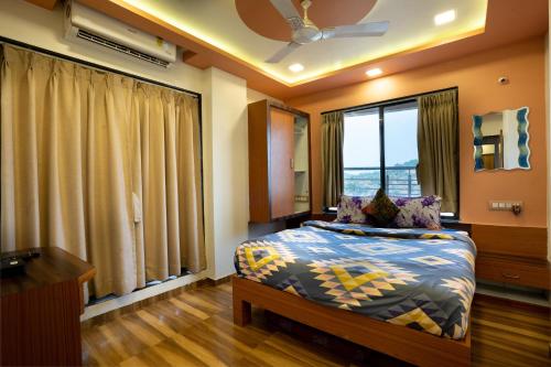 a bedroom with a bed and a large window at Pooja Villa Suites-Rooms and Pool, Igatpuri in Igatpuri