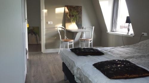 een slaapkamer met een bed en een tafel en stoelen bij Logies Ommes! in Harlingen