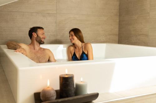 a man and a woman sitting in a bath tub at Hotel Sole Relax & Panorama in Riva del Garda