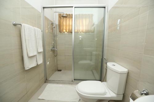 a white bathroom with a shower and a toilet at The Delight Residence in Kandy