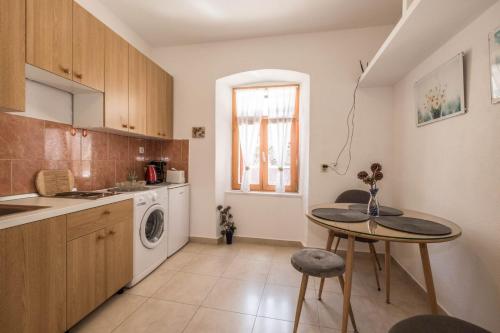 uma cozinha com uma mesa, um lavatório e uma máquina de lavar roupa em Apartment Ferienwohnung em Pula