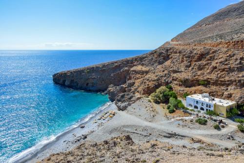 a building on a cliff next to the ocean at Ilingas Mare in Khóra Sfakíon