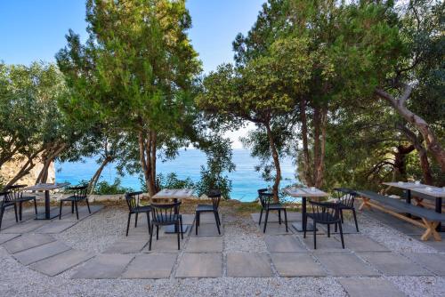 a group of tables and chairs with the ocean in the background at Ilingas Mare in Khóra Sfakíon