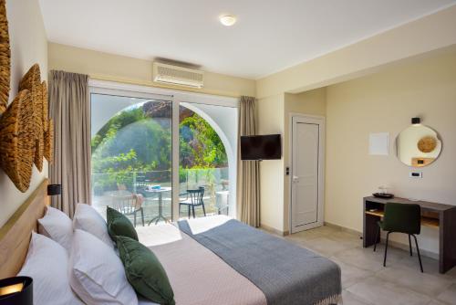 a bedroom with a bed and a balcony with a table at Ilingas Mare in Khóra Sfakíon