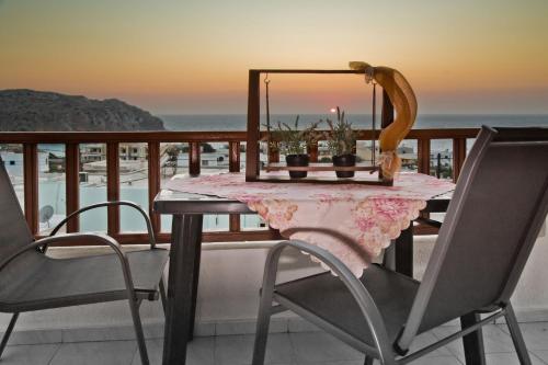 a table with a mirror and chairs on a balcony at ZoeStudios-Arkasa in Arkasa