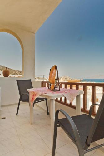 a dining room with a table and chairs on a balcony at ZoeStudios-Arkasa in Arkasa