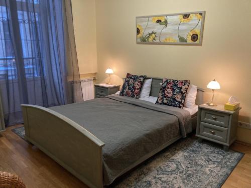 a bedroom with a large bed with two night stands at Sunflower B&B in Kyiv