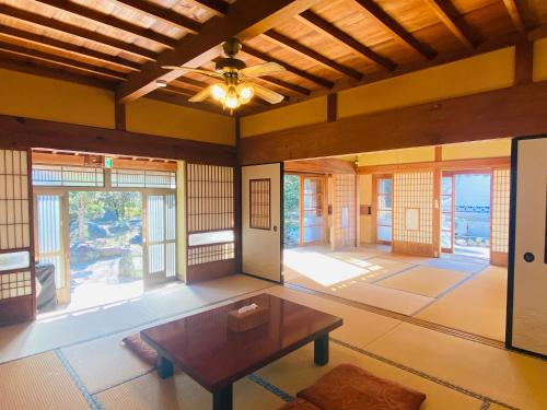 sala de estar con mesa y algunas ventanas en 一宿一景一生縁-千葉小湊鉄道高滝店, en Ichihara