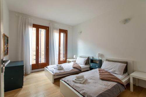 Un dormitorio con dos camas y una ventana. en Venice Lance with Lift, 2 minutes walk from the train station, en Venecia