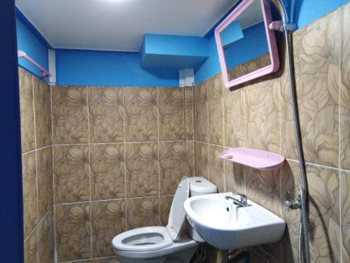 y baño con aseo, lavabo y espejo. en Krasom Homestay, en Phang-nga