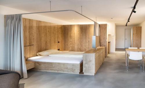 a bedroom with a bed with a wooden wall at Apartmenthaus Anna mit Self-Check-In und 24h Support in Lustenau