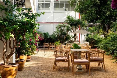 a patio with a table and chairs and plants at Hotel Thomas Bangkok in Makkasan