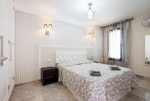 a white bedroom with a bed and a window at Las Americas de LUX 98m2 in Playa Fañabe