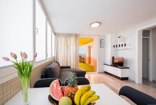 a living room with a table with fruit on it at Las Americas de LUX 98m2 in Playa Fañabe