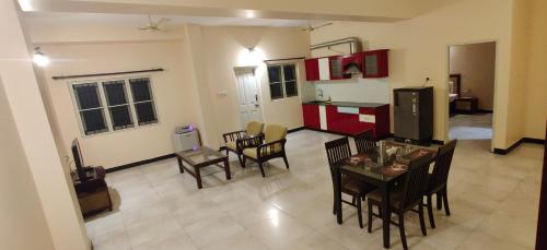 a kitchen and dining room with a table and chairs at Coral Shelters Keelavasal in Madurai