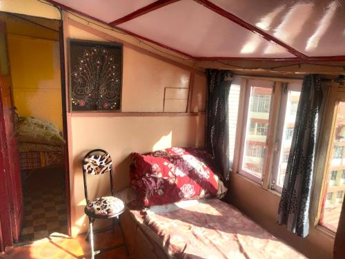 Cette petite chambre comprend un lit et deux fenêtres. dans l'établissement Kumar Guest House, à Shimla