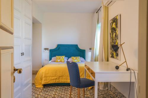 a bedroom with a bed with a desk and a chair at La Demeure in Sidi Bou Saïd