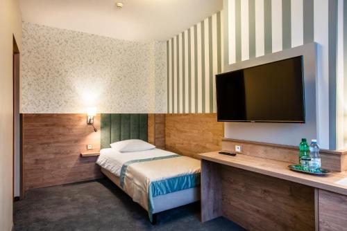 a hotel room with a bed and a flat screen tv at Hotel La Mar in Kielce