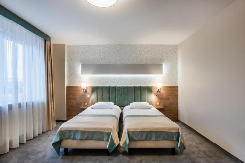 a bedroom with two beds and a window at Hotel La Mar in Kielce