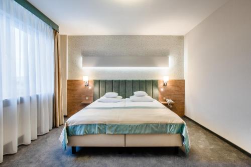 a bedroom with a large bed and a large window at Hotel La Mar in Kielce