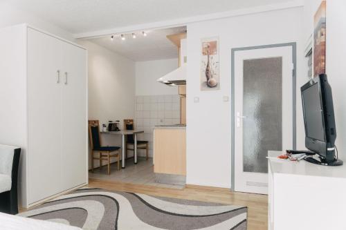 Apartment-EG-05 في دارمشتات: غرفة معيشة فيها تلفزيون ومطبخ