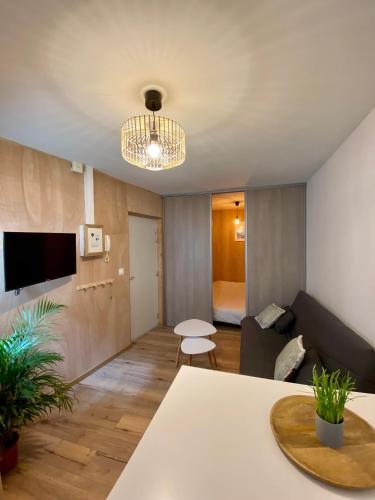 un salon avec une table et un canapé dans l'établissement N°2 L'épicéa - Appart Hôtel La Maison Sévigné, à Béthune