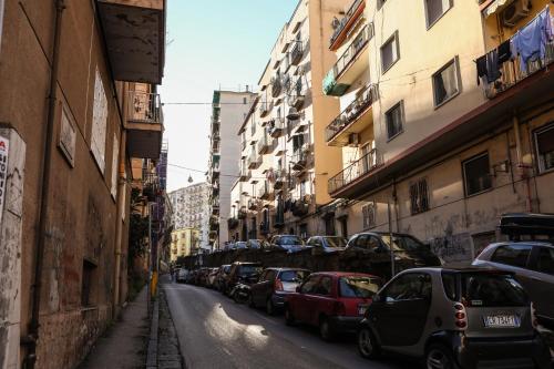 a street with cars parked on the sides of buildings at Materdays 24 in Naples