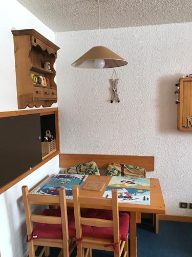 a kitchen with a wooden table and two chairs at Le Mottet -Prariond - ESF & Skis aux pieds in Valmorel
