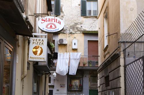 a narrow alley with towels hanging from buildings at Materdays 24 in Naples