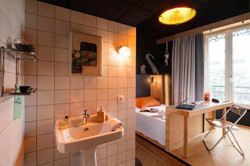 a bathroom with a sink and a bedroom with a bed at Greet Hotel Lyon Confluence in Lyon