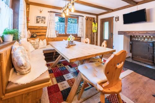 a dining room with a table and a couch at Hochfügenblick-ski- und Wanderhütte in Hochfugen
