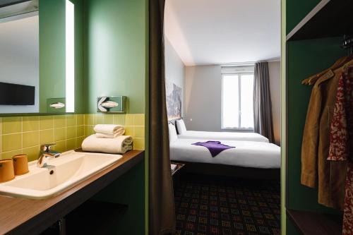 a bathroom with a sink and a bed in a room at Greet Hotel Lyon Confluence in Lyon