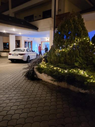 a white car parked next to a christmas tree at Hotel Miage in Aosta
