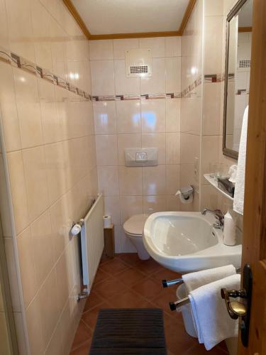 a bathroom with a tub and a toilet and a sink at Appartement Oberlacken in Sankt Johann in Tirol