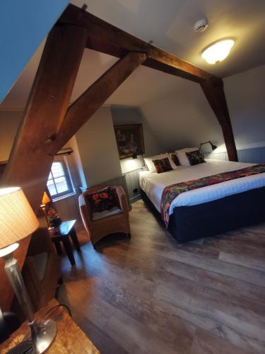 a bedroom with a bed and a chair in a room at Herberg de Gouden Leeuw in Bronkhorst