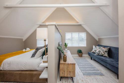 una camera da letto con un letto e un divano blu di House w Pool, Fireplace, Braai a Città del Capo