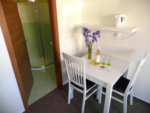 a white table with two chairs and a vase of flowers at Vila Edith Valtice in Valtice