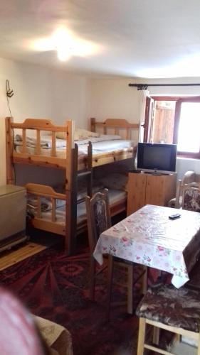 een kamer met 2 stapelbedden en een tafel bij Vikend Kuca Milica in Kopaonik