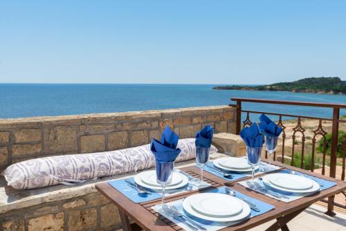 a wooden table with blue napkins and plates on it at Armonia Seaside Villas in Vasilikos