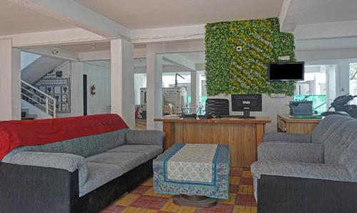 a living room with two couches and a tv at Itsy Hotels AY Plus Hotels in Kharadi